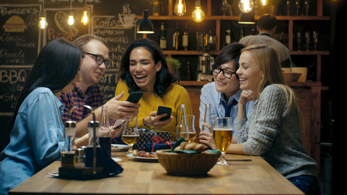 Friends at a casual restaurant having drinks and laughing.